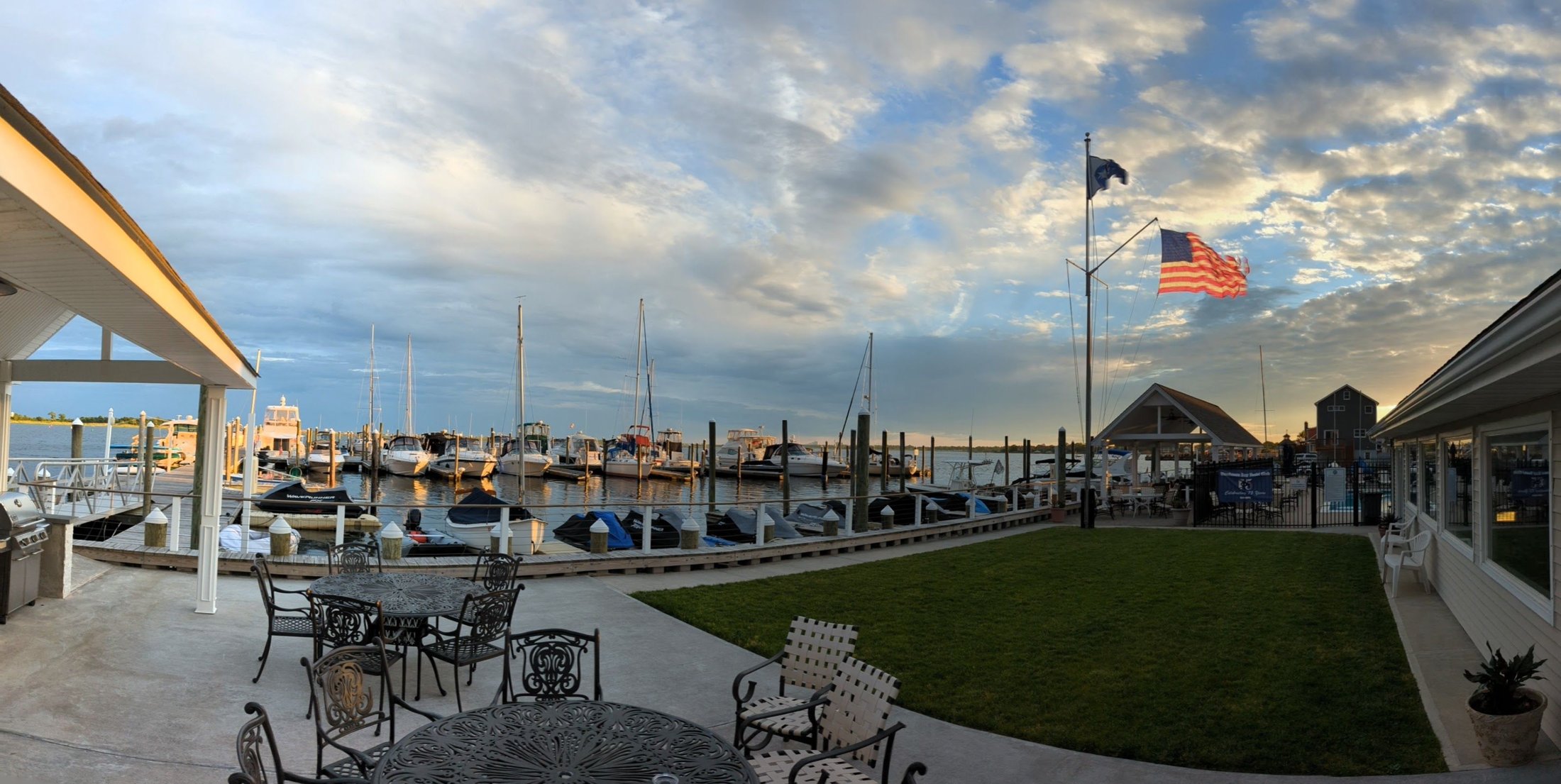 Boats, club grounds, and flags overlooking Hewlett Bay at Woodmere Bay Yacht Club