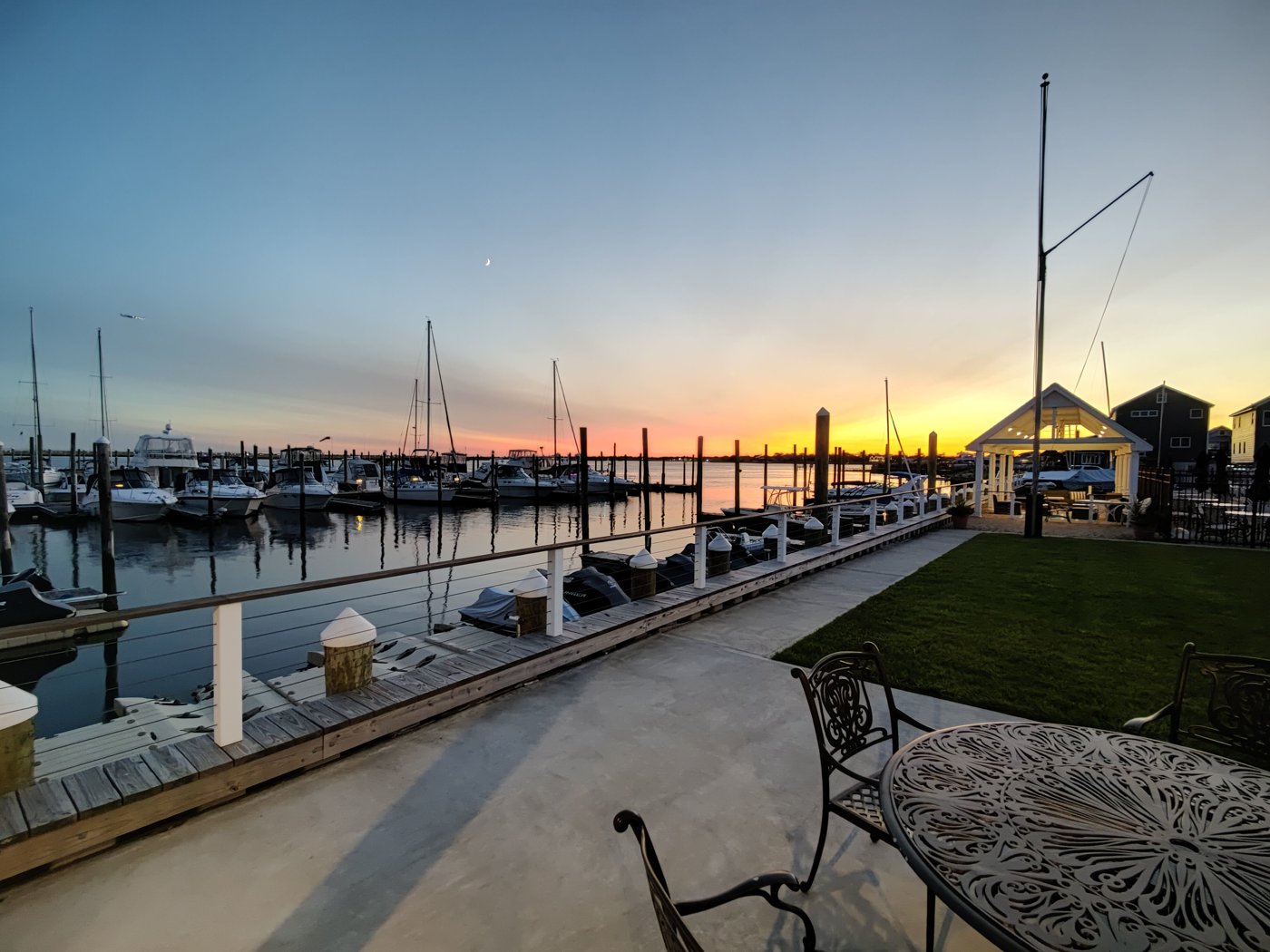 Sunset over the floating docks and boats at Woodmere Bay Yacht Club